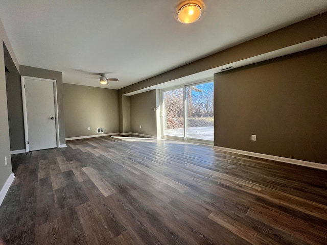 interior space with visible vents, baseboards, dark wood finished floors, and a ceiling fan