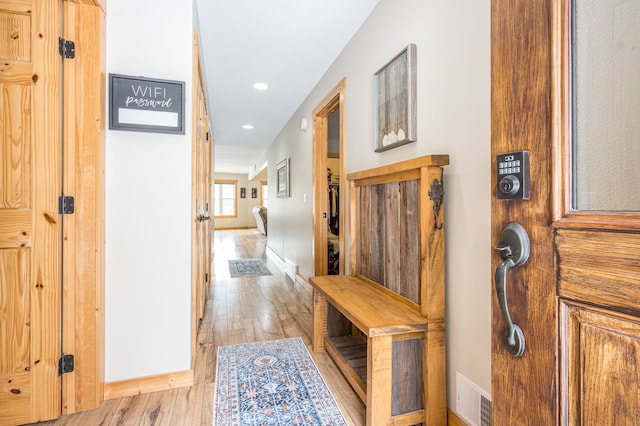 hallway with recessed lighting, light wood-type flooring, and baseboards