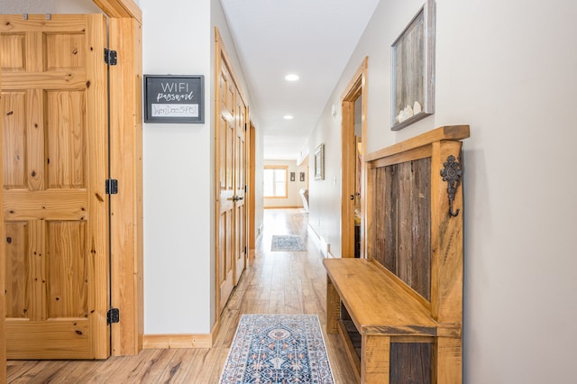 hall featuring recessed lighting, light wood-type flooring, and baseboards