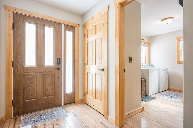 foyer with washer and dryer, baseboards, and hardwood / wood-style floors