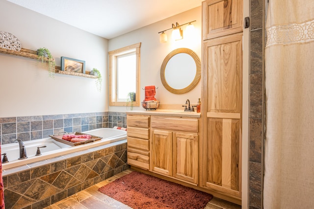 bathroom featuring vanity, a garden tub, and wood finished floors