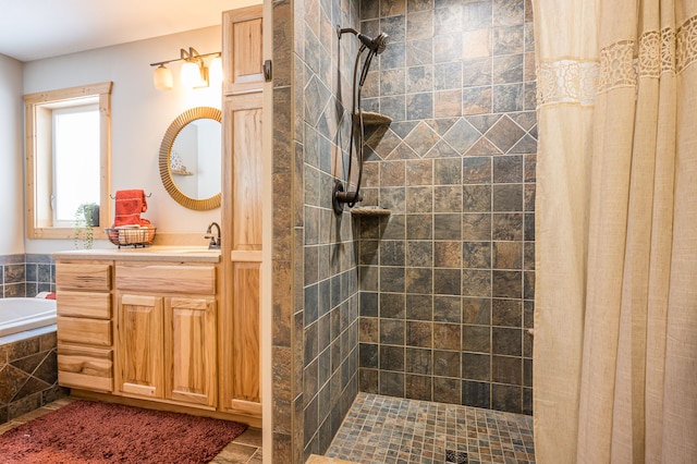 bathroom featuring vanity, a garden tub, and a tile shower