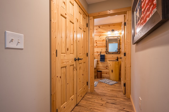 corridor with wooden walls and wood-type flooring