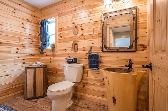 bathroom with toilet and wood walls