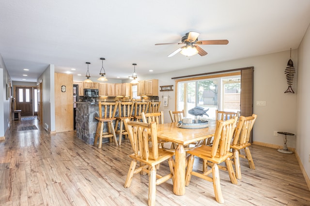 dining room with light wood-style flooring, plenty of natural light, a ceiling fan, and recessed lighting