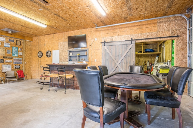 dining room with concrete flooring and a barn door