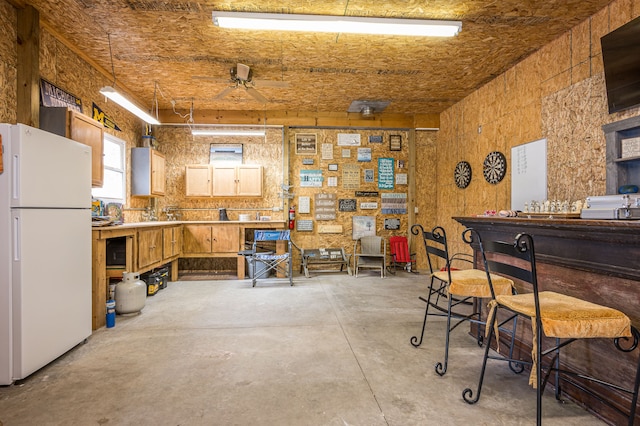 misc room with a ceiling fan and concrete flooring