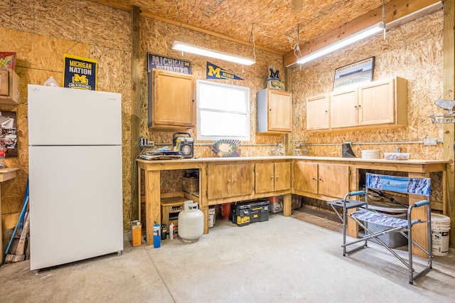 kitchen with concrete flooring, light countertops, and freestanding refrigerator