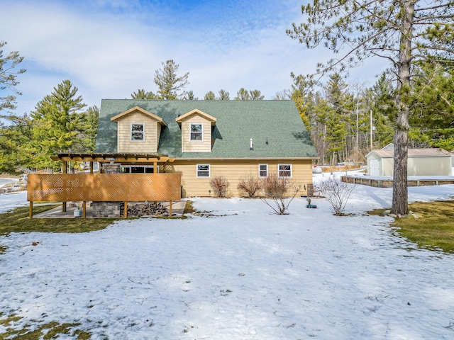 snow covered house with an outbuilding and a pergola