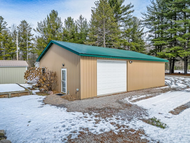 snow covered garage with a garage