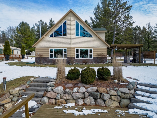 view of snow covered exterior featuring stone siding