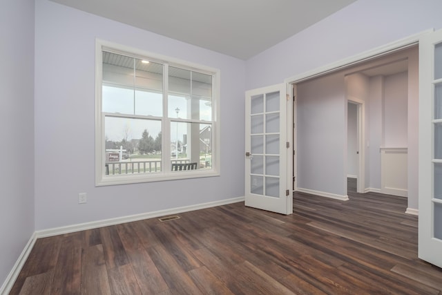 unfurnished room featuring french doors, dark wood finished floors, visible vents, and baseboards