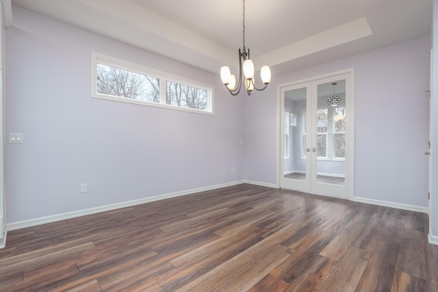 unfurnished room featuring dark wood-type flooring, a tray ceiling, french doors, and baseboards