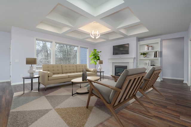 living room featuring dark wood-style flooring, coffered ceiling, baseboards, beamed ceiling, and a glass covered fireplace