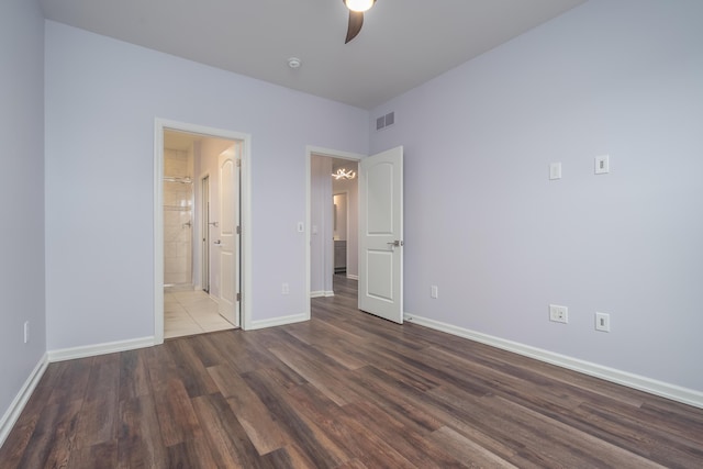 unfurnished bedroom with baseboards, visible vents, ceiling fan, wood finished floors, and ensuite bathroom