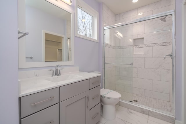 full bathroom featuring marble finish floor, a shower stall, toilet, and vanity