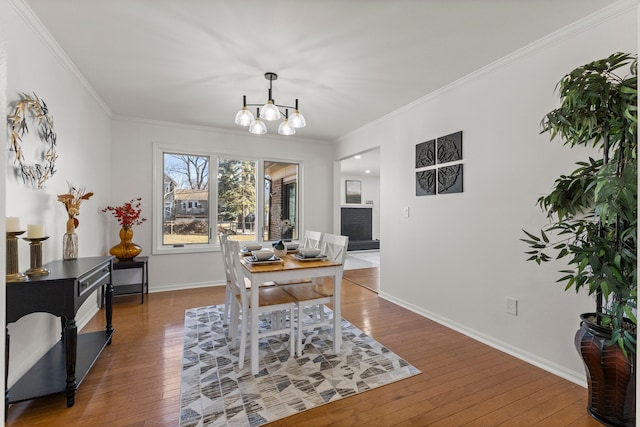 office featuring baseboards, wood-type flooring, a chandelier, and ornamental molding