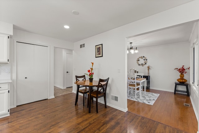 dining space with visible vents, dark wood-type flooring, and baseboards