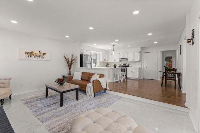 living room featuring recessed lighting, marble finish floor, and baseboards