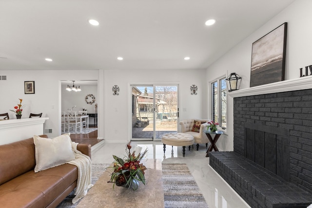 living room featuring visible vents, an inviting chandelier, recessed lighting, a brick fireplace, and marble finish floor