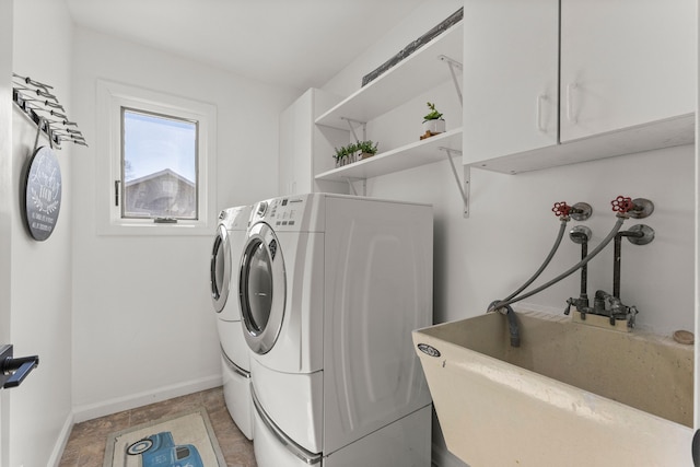 laundry room with a sink, baseboards, cabinet space, and independent washer and dryer