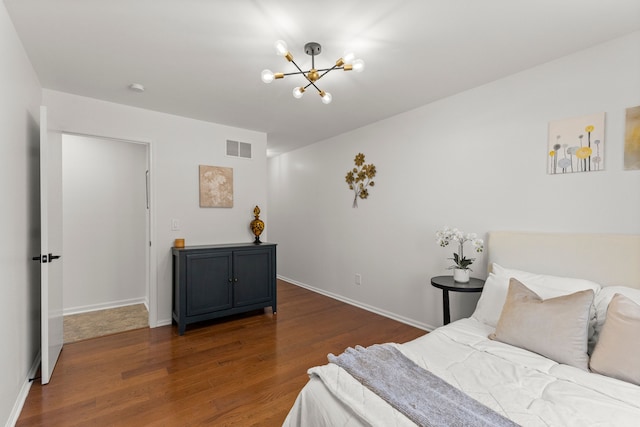 bedroom with visible vents, baseboards, a notable chandelier, and wood finished floors