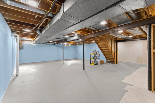 unfinished basement featuring stairs