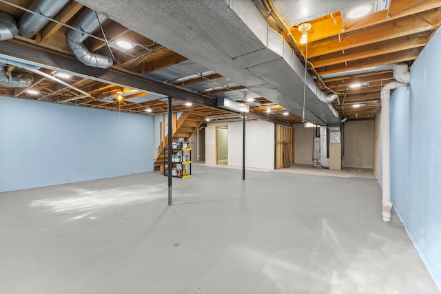 unfinished below grade area featuring heating unit, stairway, and water heater