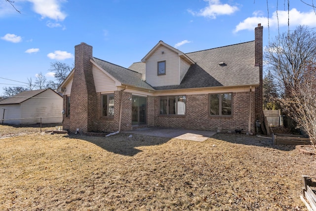 back of property with brick siding, a chimney, and fence