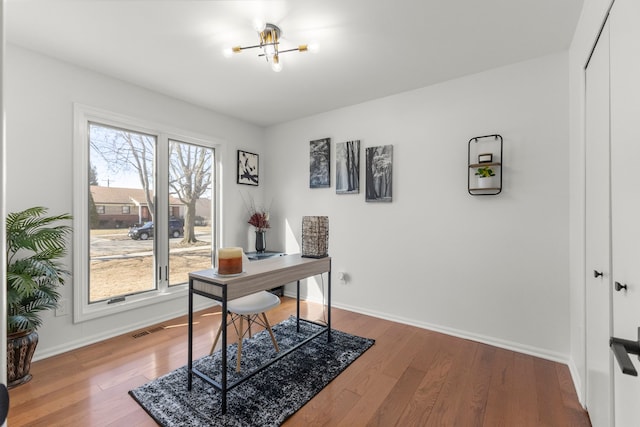 office featuring visible vents, baseboards, and hardwood / wood-style flooring