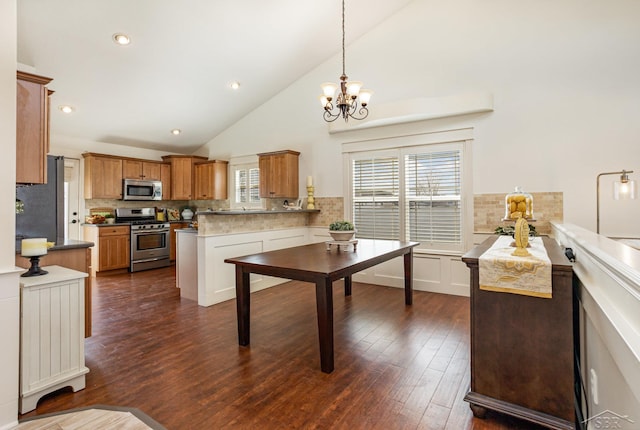 kitchen with stainless steel appliances, backsplash, a peninsula, and dark wood finished floors