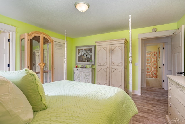 bedroom featuring light wood finished floors and a textured ceiling