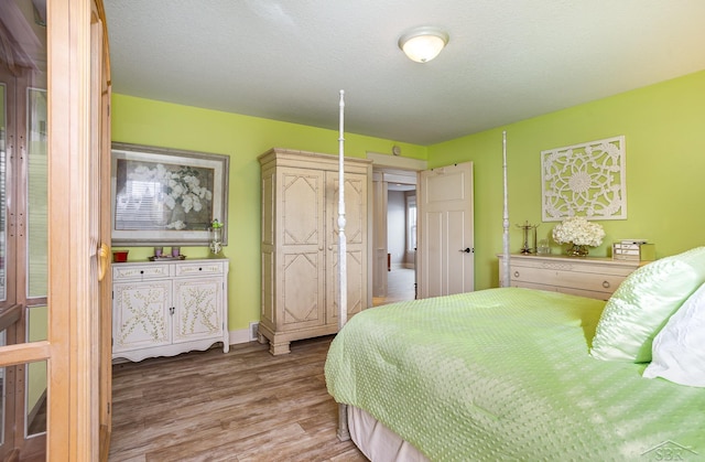 bedroom featuring a textured ceiling and wood finished floors