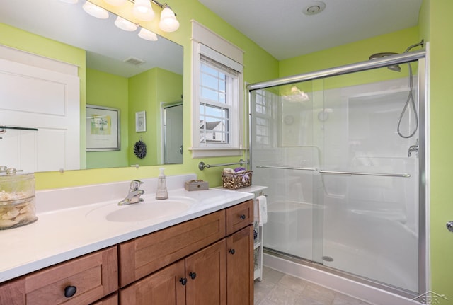 bathroom featuring a stall shower, vanity, and visible vents