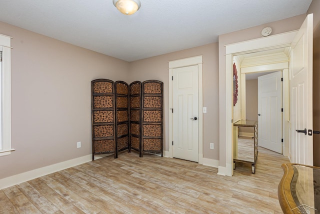 empty room featuring light wood-type flooring and baseboards