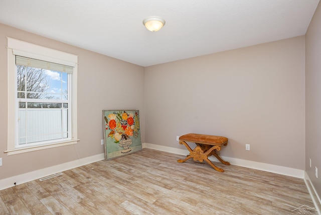 recreation room featuring wood finished floors, visible vents, and baseboards