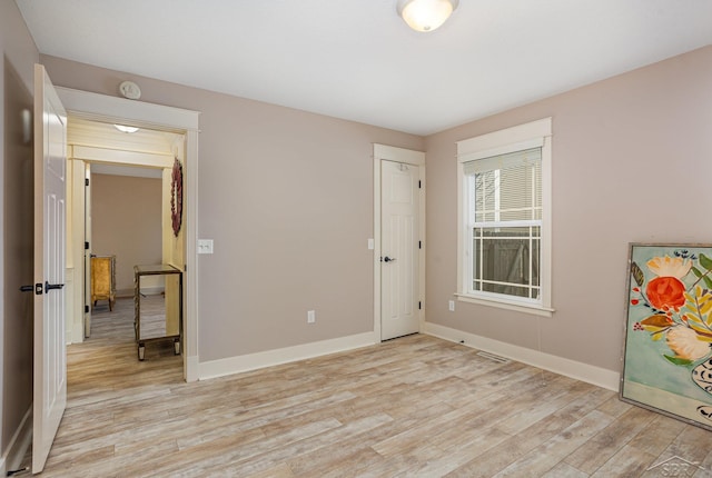 bedroom with light wood-type flooring and baseboards