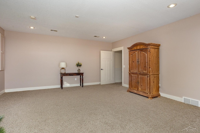 spare room featuring light carpet, baseboards, visible vents, and recessed lighting