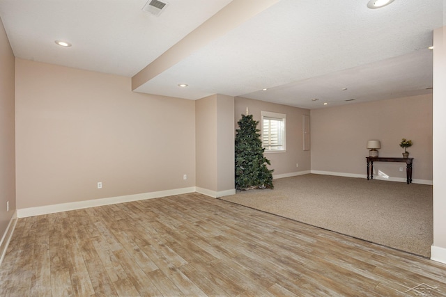 empty room with recessed lighting, light wood-type flooring, visible vents, and baseboards