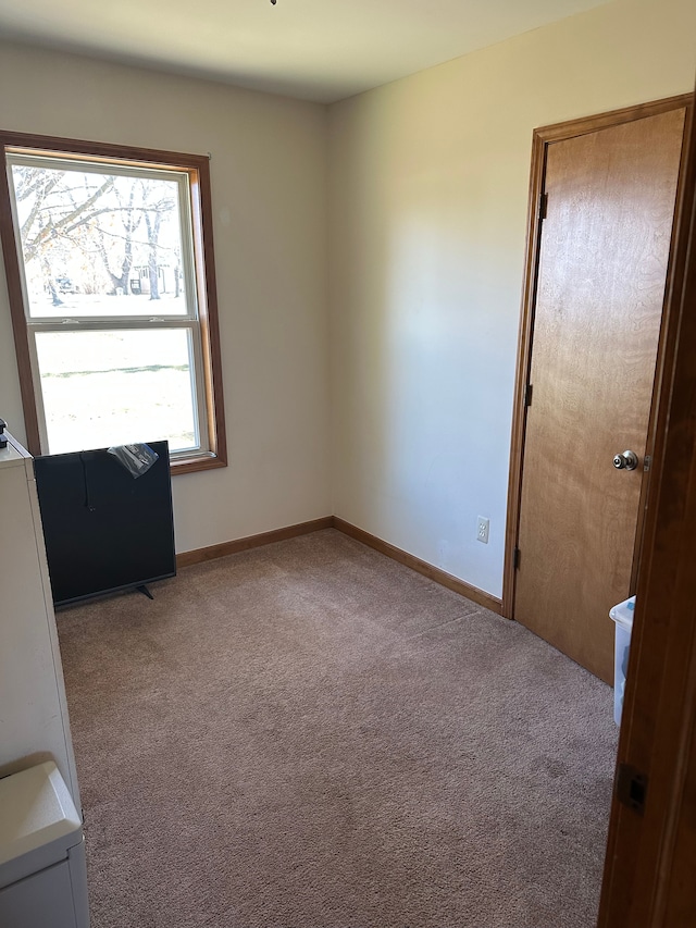 carpeted empty room featuring baseboards