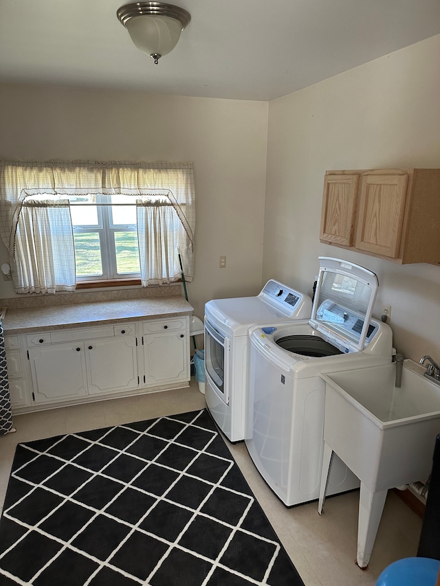 laundry area featuring separate washer and dryer, cabinet space, and a sink