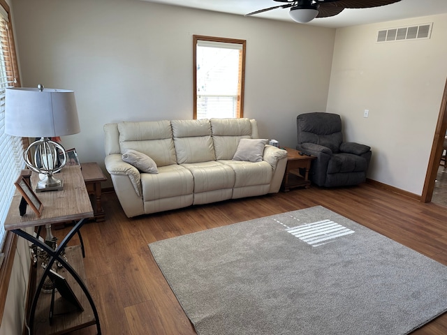 living room with ceiling fan, wood finished floors, visible vents, and baseboards