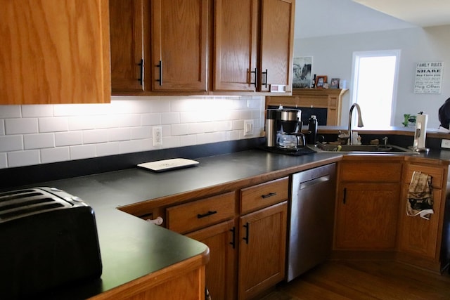 kitchen featuring a sink, brown cabinets, dark countertops, and dishwasher