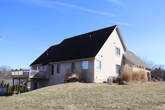 rear view of property with a yard and a wooden deck