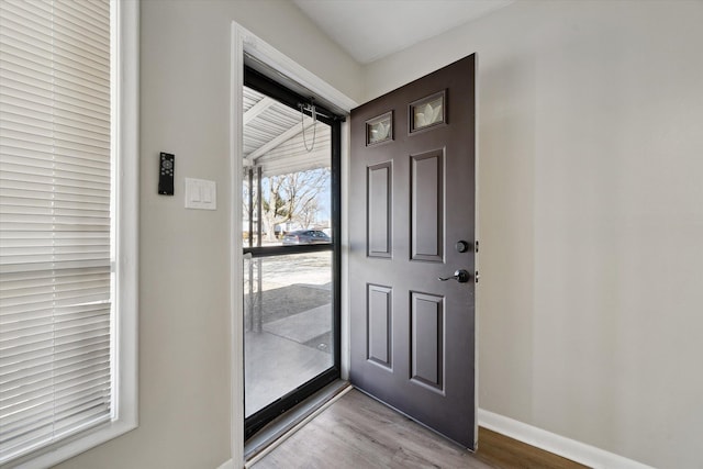 entryway featuring baseboards and wood finished floors