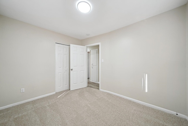 unfurnished bedroom with carpet floors, a closet, and baseboards