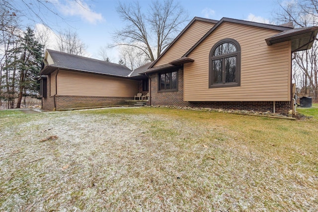 view of property exterior with a lawn and brick siding