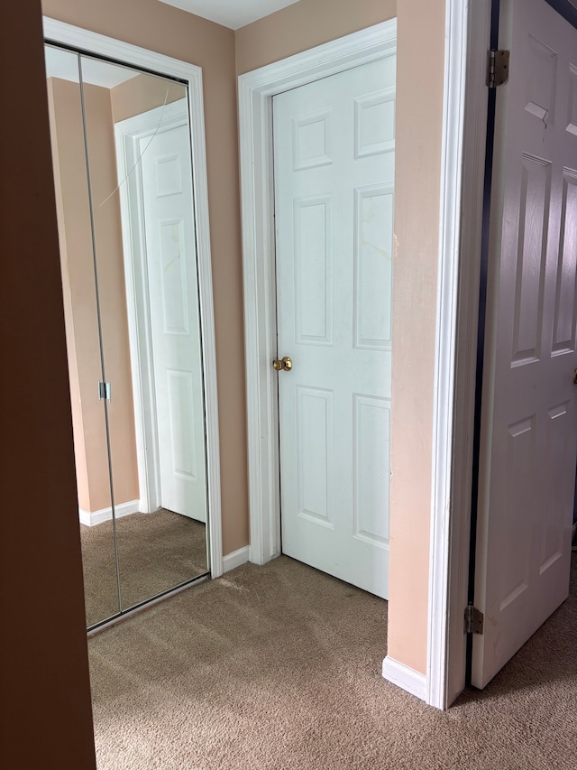 unfurnished bedroom with a closet, carpet floors, and baseboards