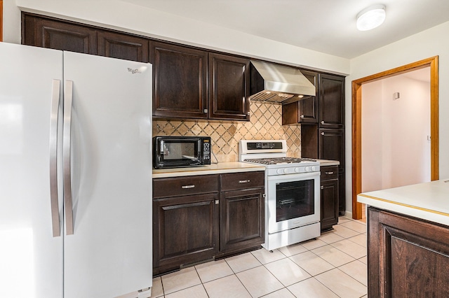 kitchen featuring decorative backsplash, white appliances, wall chimney range hood, and light countertops