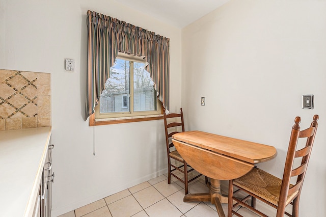 dining space featuring light tile patterned floors and baseboards